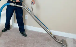 Professional operating a liquid removal machine on a carpeted floor in Minneapolis, MN